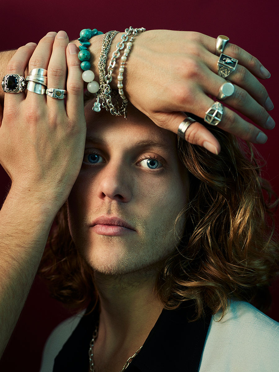 Studio portrait of musician Jimmy Morris, with his brother Harry's hands covering his right eye and forehead.